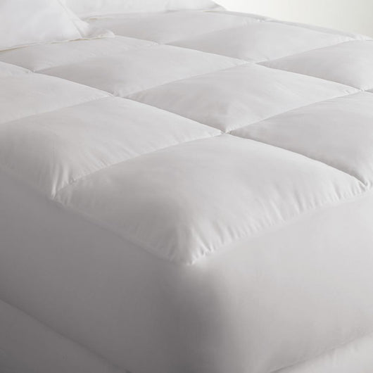 Down alternative mattress enhancer and mattress cushion on a bed